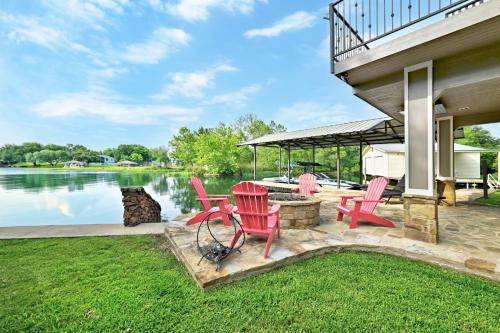 a patio with red chairs and a grill next to the water at Paradise Cove in Granite Shoals