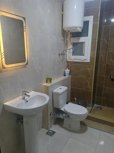 a bathroom with a toilet and a sink at بورتو الجولف in Dawwār Abū Maḩrūs