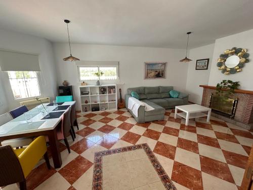 a living room with a couch and a table at CASA RURAL MALAGA,VILLA FAMARA,10 personas,DESAYUNO ANDALUZ INCLUIDO EN EL PRECIO in Málaga