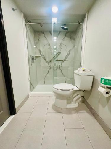 a bathroom with a toilet and a glass shower at La Quinta Inn by Wyndham Costa Mesa Orange County in Costa Mesa