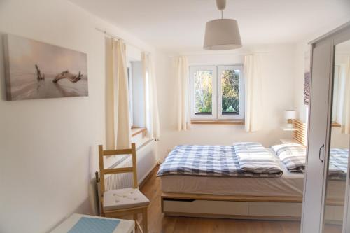 a small bedroom with a bed and two windows at Wild Wine House in Gdynia