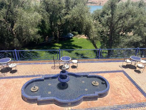 a view of a patio with a table and chairs at Dar NFis Suites et chambres de luxe dans un havre de paix vue paradisiaque au bord du lac in Lalla Takerkoust