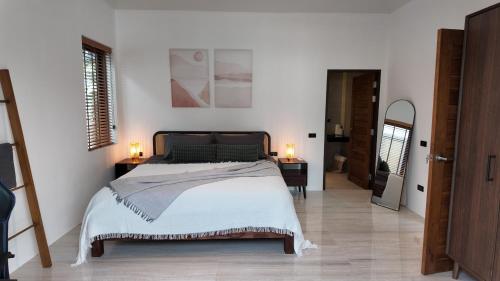 a bedroom with a large bed and two lamps on tables at ILKI 2BR Pool Villa in Ko Phangan