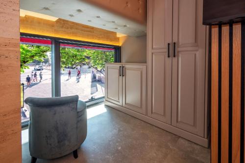 a room with a chair in front of a window at Central Pazar Rooms in Split