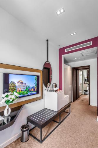 a living room with a tv on a wall at Ivy Garden Hotel Baku in Baku
