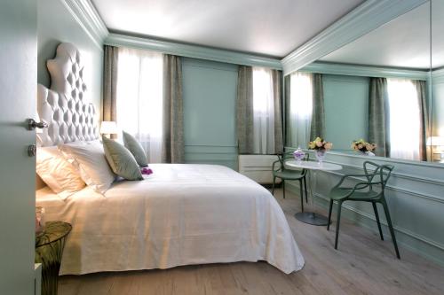 a bedroom with a white bed and a desk and a window at Aquamare, boutique b&b in Venice