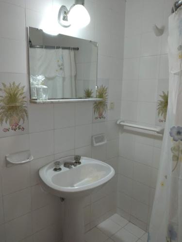 a white bathroom with a sink and a mirror at Plaza hotel in Dolores