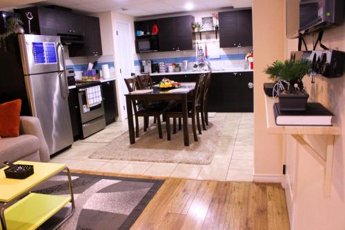 a kitchen and living room with a table and a refrigerator at Entire suite Queen BRM Big Window Prvt Entry Patio in Edmonton