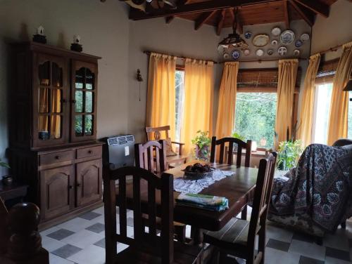 ein Esszimmer mit einem Holztisch und Stühlen in der Unterkunft Casas Buen Camino y La Magia in Sierra de la Ventana