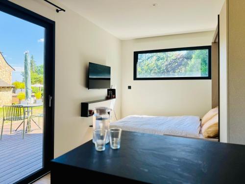 a bedroom with a bed and a table with glasses on it at Domaine du Mafay - LODGE PROVENÇALE in Bourg-des-Comptes