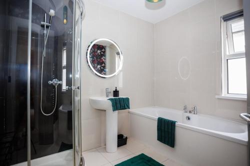 une salle de bain blanche avec lavabo et douche dans l'établissement Raven Willow, à Belfast