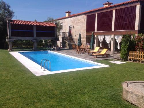 uma piscina num quintal ao lado de uma casa em Casa da Ponte do Porto em Amares