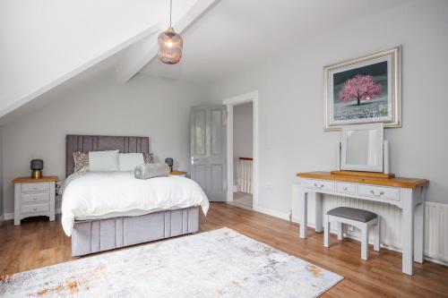 une chambre blanche avec un lit et un bureau dans l'établissement Raven Willow, à Belfast