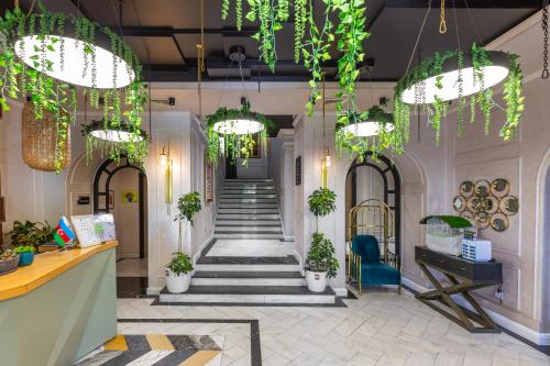 a lobby with a staircase and potted plants at Ivy Garden Hotel Baku in Baku