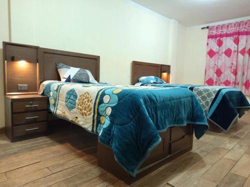 een slaapkamer met een bed met een blauw dekbed bij Central Stay Departamentos II in Oruro