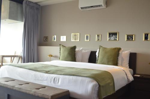 - une chambre dotée d'un grand lit avec des draps blancs et des oreillers verts dans l'établissement Hive Roma By G Hotels, à Mexico