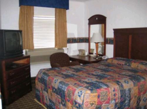 a hotel room with a bed and a television at Martin House Motel Brookfield in Brookfield