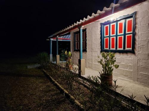a building with a flag on the side of it at night at Cabaña hospedaje Masinga in La India
