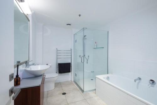 a bathroom with a sink and a toilet and a shower at Large Executive Inner City Apartment in Wellington