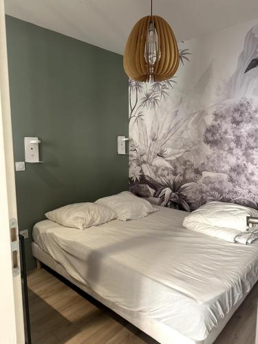 a bed in a bedroom with a painting on the wall at T2 Au Coeur de Montpellier in Montpellier