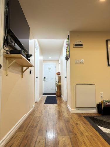 a hallway with a door and a television on a wall at Entire suite Queen BRM Big Window Prvt Entry Patio in Edmonton