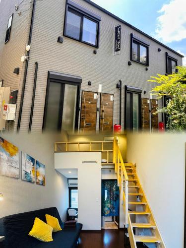a house with yellow pillows and a staircase in front of it at Lucky you! YOTSUYA in Tokyo