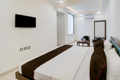 a bedroom with a large bed with a tv on the wall at Hotel O Giriraj Palace by Govindam in Jaipur