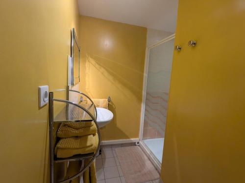 a yellow bathroom with a sink and a shower at Chambre Jonquille - 3 Pers, Nature et Confort - FR-1-589-730 in Moyenmoutier