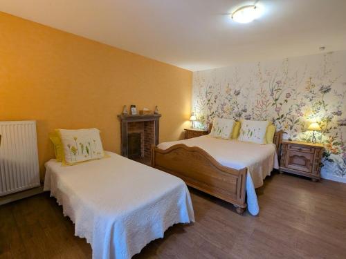 a bedroom with two beds and a wall with flowers at Chambre Jonquille - 3 Pers, Nature et Confort - FR-1-589-730 in Moyenmoutier