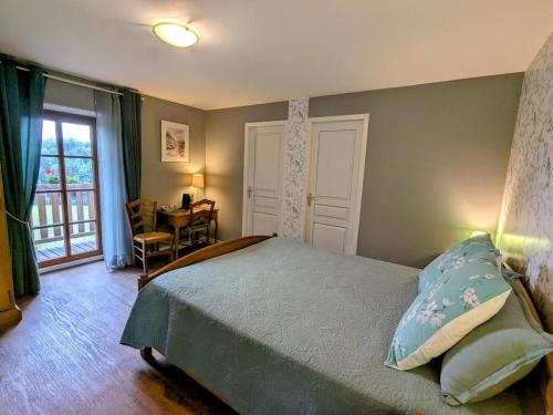 a bedroom with a bed and a table and a window at Chambre Double avec Petit Déjeuner dans Bâtisse Historique - FR-1-589-717 in Moyenmoutier