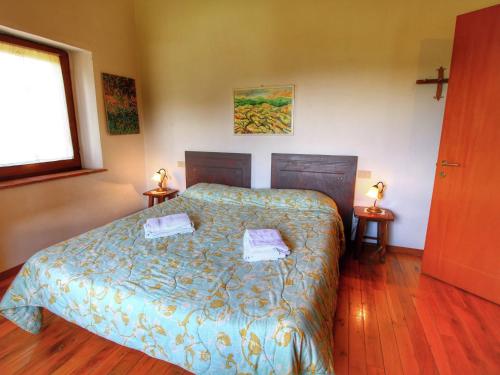 a bedroom with a bed with two towels on it at Farmhouse in Castiglione Dorcia in San Quirico dʼOrcia