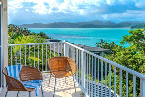 a balcony with two chairs and a view of the ocean at La Bella Waters 3 - Oceanview's, Pool, Buggy and Transfers in Hamilton Island