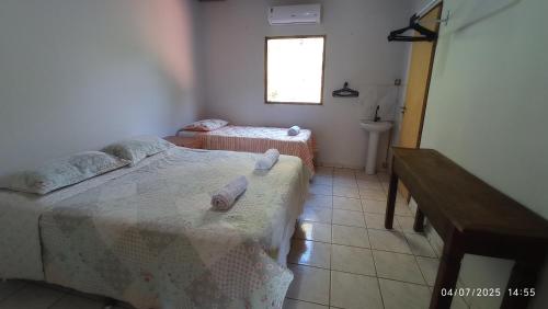 a bedroom with two twin beds and a window at Pouso do Sol in Pirenópolis
