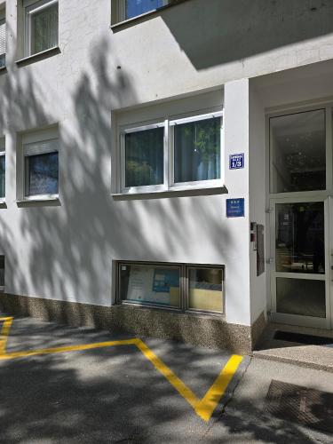 a white building with windows and a yellow parking lot at Apartments with WiFi Slavonski Brod, Slavonija - 24649 in Slavonski Brod