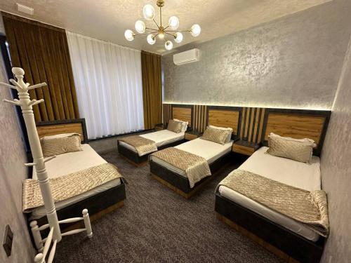 a room with four beds and a chandelier at Villa Lux I in Chorwoq
