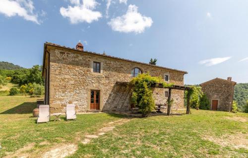 an old stone house with two white chairs in front of it at 6 Bedroom Awesome Home In Anghiari in Anghiari