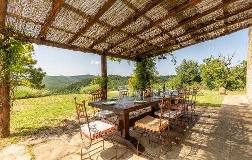 a wooden table and chairs under a pergola at 6 Bedroom Awesome Home In Anghiari in Anghiari