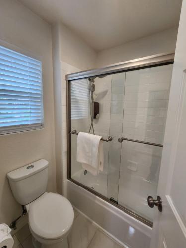 a bathroom with a toilet and a glass shower at Family-Friendly Sunny SD Escape, Sleeps 8, Beach, Zoo, Downtown & Convention Center in San Diego