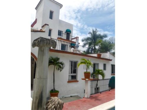 a white house with palm trees in front of it at Hotel Bajo el Volcan in Cuernavaca