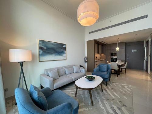 a living room with a couch and chairs and a table at Luxury 1BR Apartment Address beach resort in Rayyā