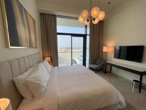 a bedroom with a bed and a television and a desk at Luxury 1BR Apartment Address beach resort in Rayyā