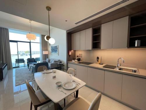 a kitchen and living room with a table and chairs at Luxury 1BR Apartment Address beach resort in Rayyā