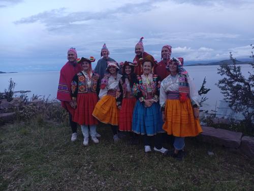a group of people in traditional dress posing for a picture at Kantuta tours llachon in Llachon