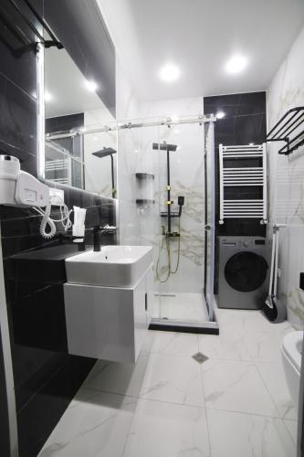 a white bathroom with a sink and a shower at Gori Apartments in Gori