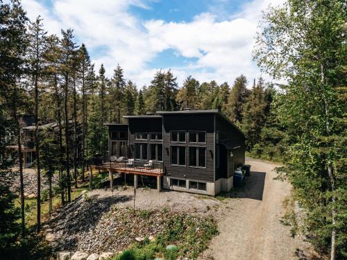 a house on a dirt road in the woods at Chalet Ankoay - Relaxation Nature & Private Spa in Saint Come