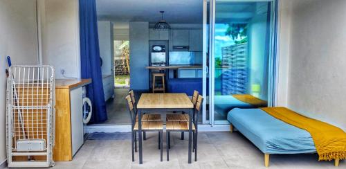 a room with a bed and a table and a bedroom at Studio Bel Air in Punaauia