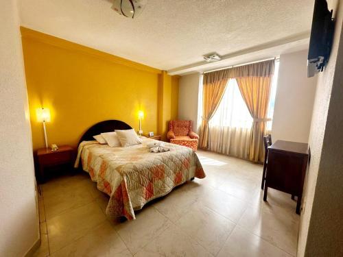 a bedroom with a bed and a yellow wall at Royal Ruiz in Ibarra