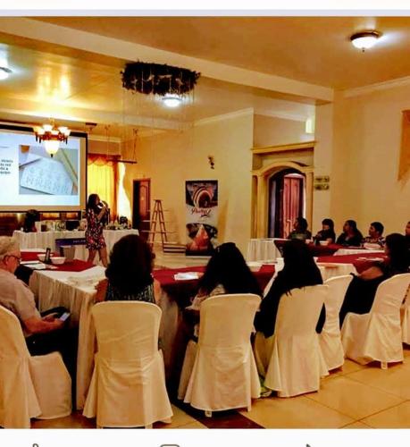 a group of people sitting in chairs in a room at Royal Ruiz in Ibarra