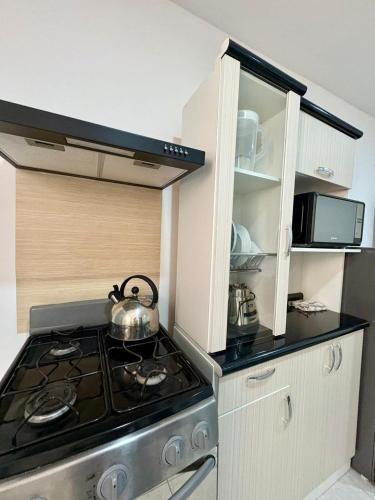 a kitchen with a stove with a tea kettle on it at Apartamento Independiente 2 camas individuales in Lima