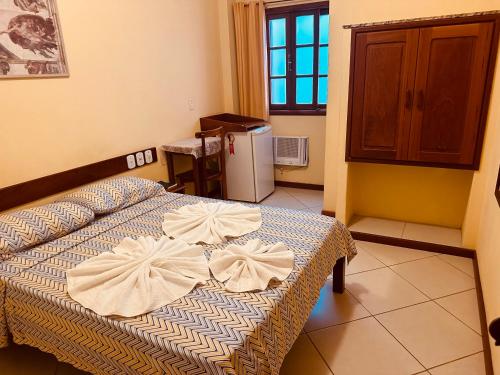 a bedroom with a bed with bows on it at Pousada Maravista in Anchieta